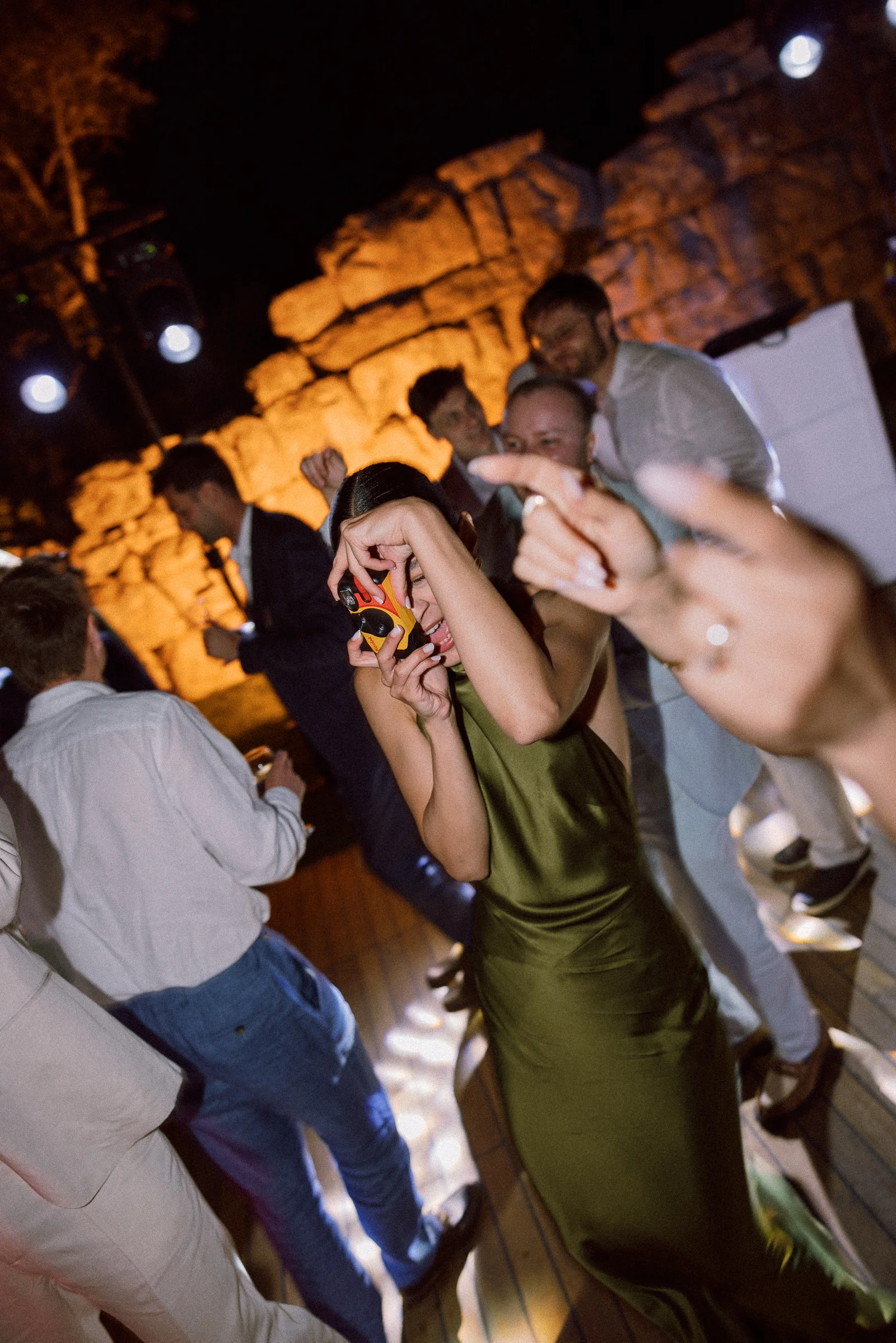 Guests dancing beside the lit stone wall, The Marmara Bodrum