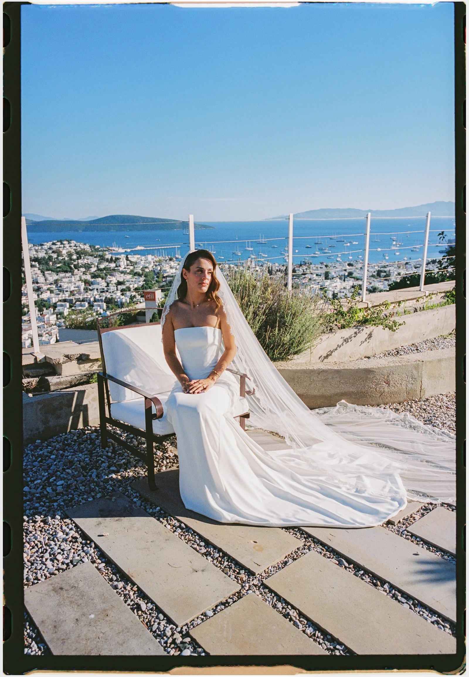 Bride seated on the bench above the bay, shot on film, The Marmara Bodrum